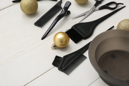 Hairdresser's tools with Christmas balls on white wooden background, closeupの写真素材