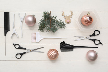Hairdresser's tools with Christmas balls and fir branches on white wooden backgroundの写真素材