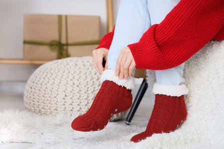 Woman in warm red socks at home on Christmas Eve, closeupの写真素材