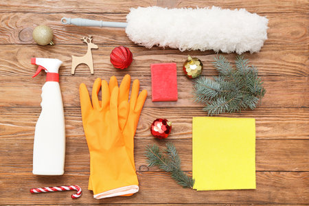 Cleaning supplies with Christmas balls and fir branches on wooden backgroundの写真素材