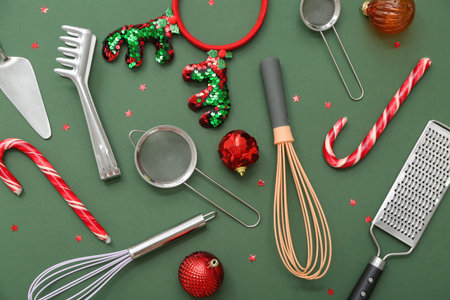 Cooking utensils with Christmas decor on green background