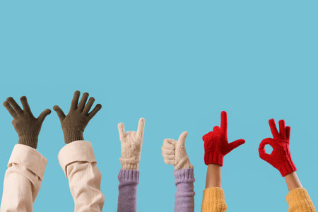 Women in warm gloves gesturing on blue backgroundの写真素材