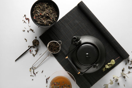 Composition with tea pot, bamboo mat and strainer on white backgroundの写真素材
