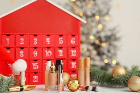 Makeup products with Christmas Advent calendar on table against blurred lights, closeupの写真素材