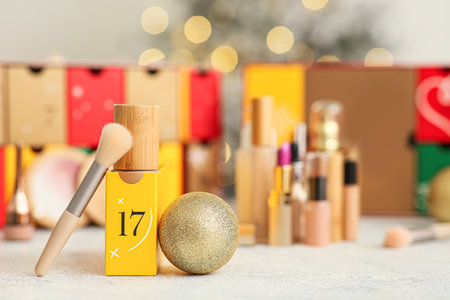 Makeup products with Christmas ball and Advent calendar on table, closeupの写真素材