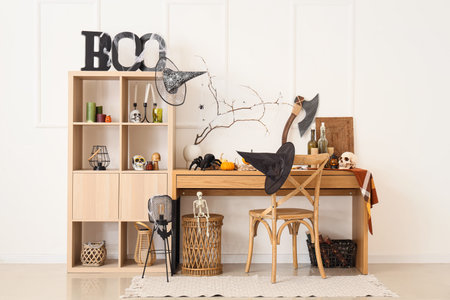 Light room with workplace and shelving unit decorated for Halloween celebrationの写真素材