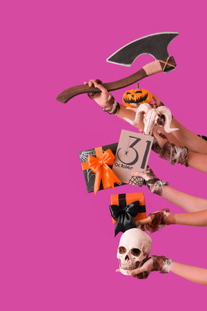 Female bandaged hands with Halloween gifts, cards, skulls, pumpkin and ax on purple backgroundの写真素材