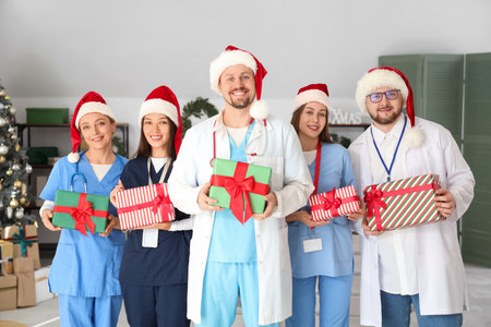 Group of doctors in Santa hats with Christmas presents at hospitalの写真素材