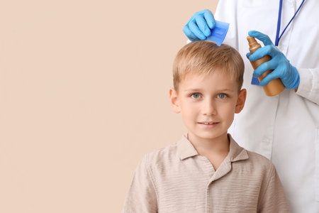 Female doctor with remedy brushing little boy's hair for pediculosis on beige background, closeup