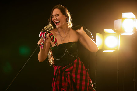 Female singer with microphone and glowing lamps on stage