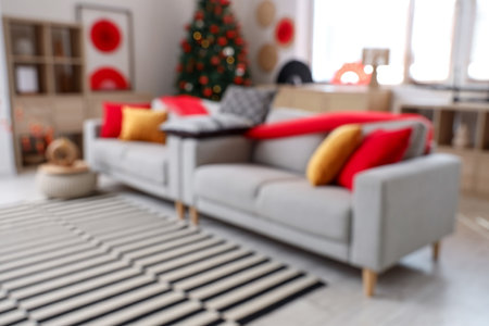 Blurred view of living room decorated for Japanese New Year celebration with sofas and fir treeの写真素材