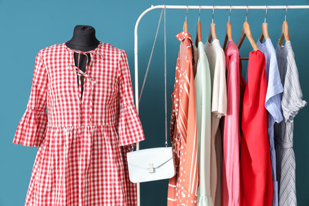 Mannequin and rack with clothes near blue wall in dressing roomの写真素材