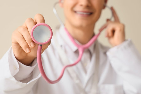 Male medical intern with stethoscope on beige background, closeupの写真素材