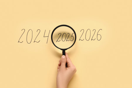 Female hand with magnifier and figures denoting years 2024-2026 on color background, closeup