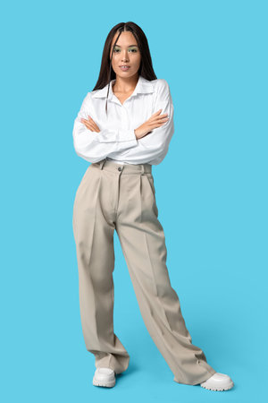 Fashionable young Asian woman with stylish mint makeup on blue backgroundの写真素材