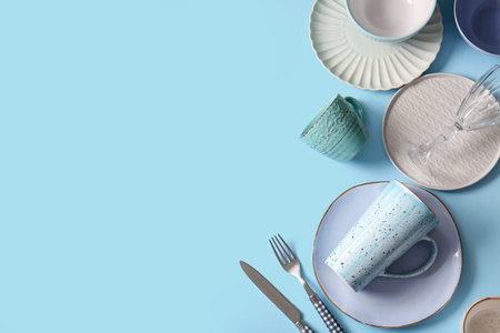Different tableware on blue background. Top view