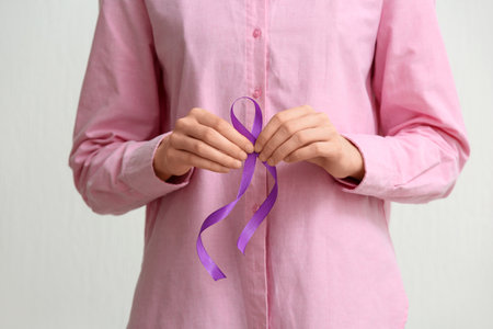 Woman holding purple ribbon on white background. World Cancer Dayの写真素材