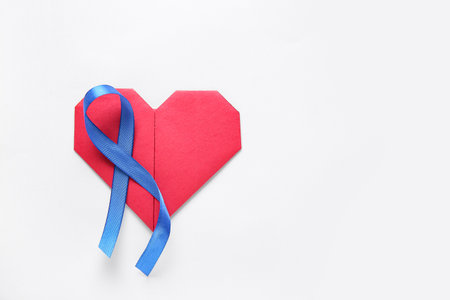 Blue ribbon and heart on white background. World Cancer Dayの写真素材