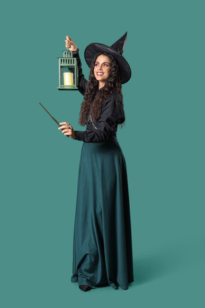 Young witch with wand and lantern on green background