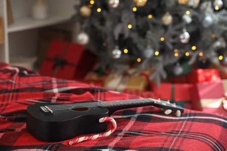Ukulele on bed in room decorated for Christmas, closeupの写真素材