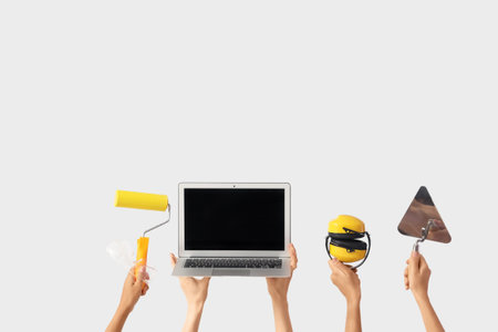 Women with architect's supplies and blank laptop on light backgroundの写真素材