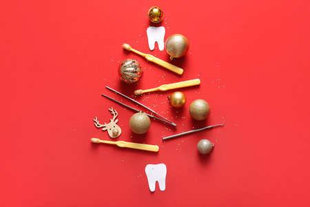 Christmas tree made of dentist's tools and decorations on red backgroundの写真素材