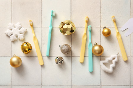 Composition with different toothbrushes and Christmas decorations on light tile backgroundの写真素材