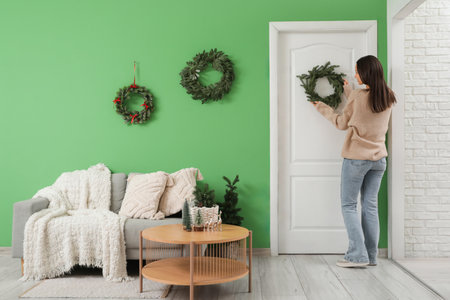 Woman Christmas wreath on door at hanging home, back viewの写真素材