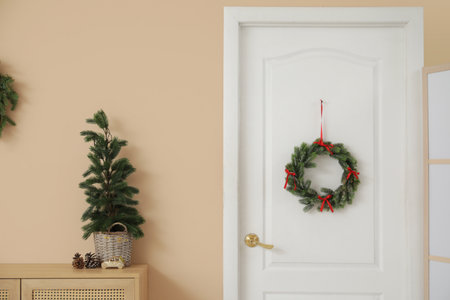 Christmas wreath on white door in roomの写真素材