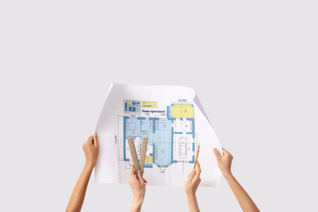 Architects with house plan, rulers and pencil on light background