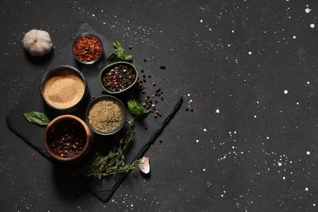 Composition with fresh aromatic spices and herbs on dark background