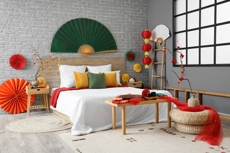 Interior of bedroom with bed, tables and decor for Chinese New Year celebrationの写真素材