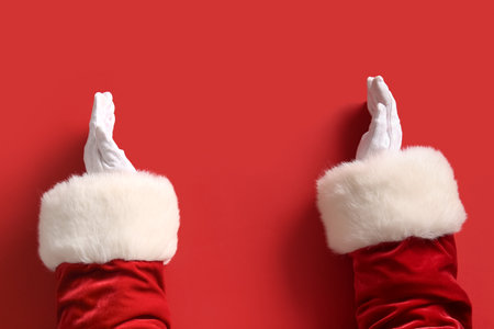 Santa Claus holding something on red background, closeupの写真素材