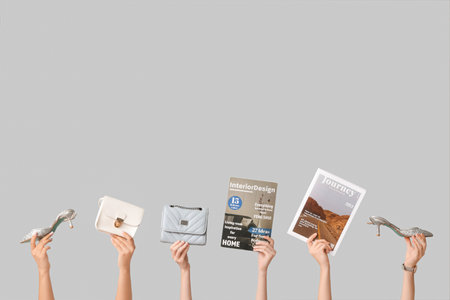 Female hands with different magazines, high heels and stylish bags on gray backgroundの写真素材