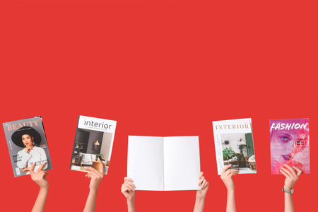 Female hands with different magazines on red backgroundの写真素材