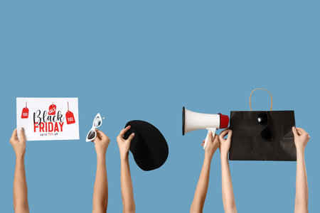Hands with shopping bag, megaphone and accessories on blue background. Black Friday saleの写真素材