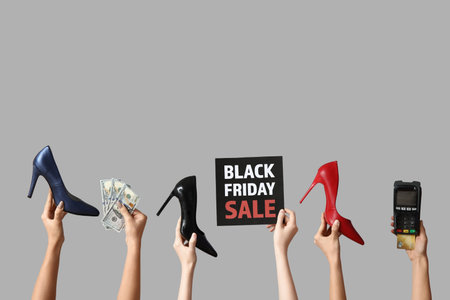 Hands with payment terminal, money and shoes on gray background. Black Friday saleの写真素材
