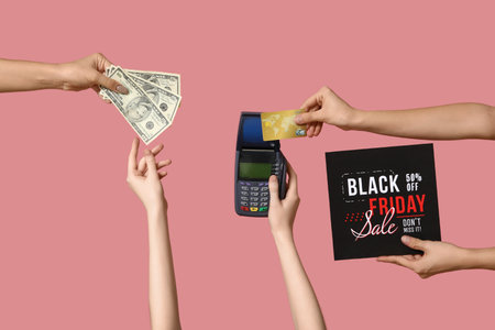 Hands with payment terminal, money and credit card on pink background. Black Friday saleの写真素材