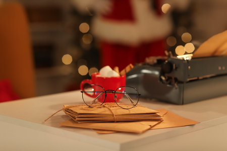 Typewriter, Christmas letters and cup of hot cocoa on table at night, closeupの写真素材