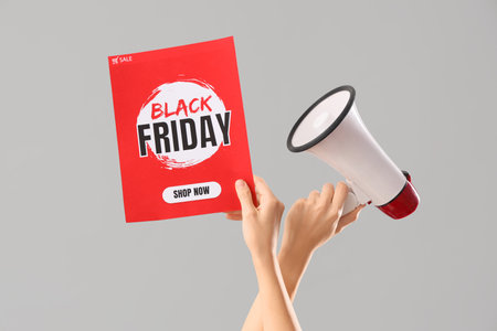 Female hands with megaphone and text BLACK FRIDAY SALE on gray backgroundの写真素材