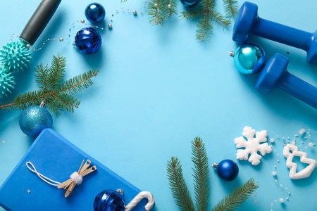Frame made of sports equipment, Christmas decorations and fir branches on color backgroundの写真素材