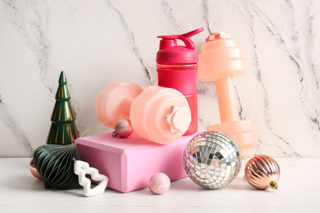 Composition with sports equipment, bottle of water and beautiful Christmas decorations on light backgroundの写真素材