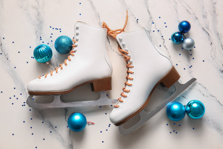 Composition with ice skates and Christmas balls on light backgroundの写真素材
