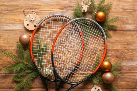 Composition with tennis rackets, fir branches and Christmas decorations on wooden background, closeupの写真素材
