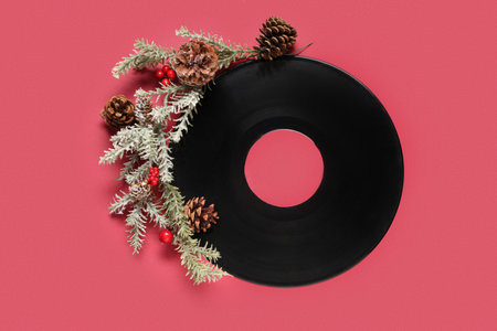 Vinyl disc with Christmas tree branches and pine cones on red backgroundの写真素材