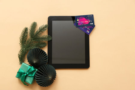 Composition with tablet computer, credit cards and Christmas decorations on color backgroundの写真素材