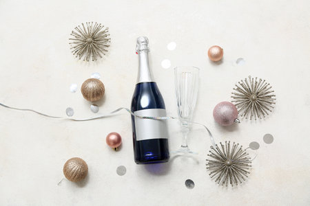 Bottle of champagne with glass and Christmas decorations on grunge white backgroundの写真素材