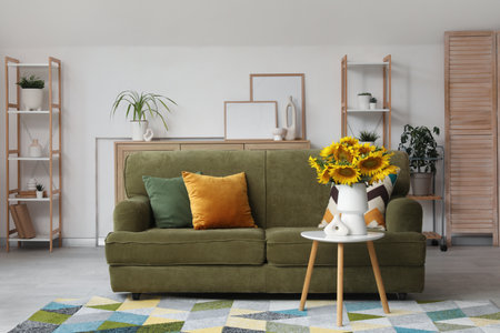 Interior of living room with green sofa and sunflowers on coffee tableの写真素材
