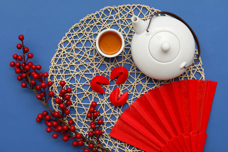 Tea with fortune cookies and Chinese symbols on blue background. New Year celebration