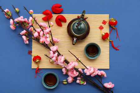 Tea with fortune cookies, sakura and Chinese symbols on blue background. New Year celebrationの写真素材